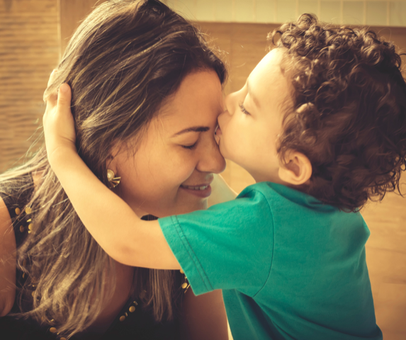 Child Kissing Forehead of Women